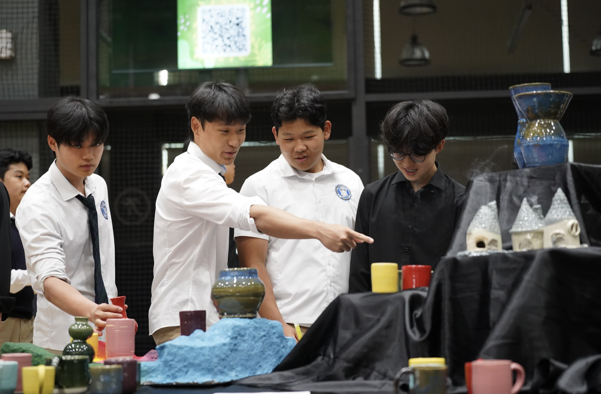 Immersed in vibrant, intricate ceramic designs, students stand in awe. They share observations and reflections on the craftsmanship behind each piece. 